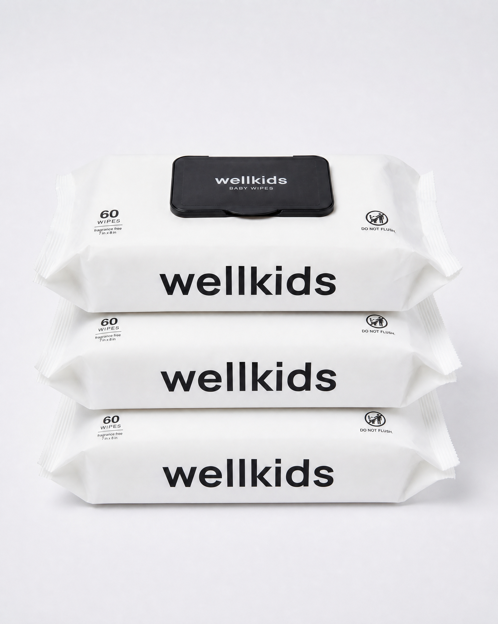 Three stacked packs of Wellkids baby wipes on a clean white background. The packs are white with bold black text reading 'wellkids' and a small black flap on top showing the brand name.