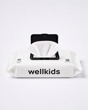A pack of Wellkids baby wipes with the lid open, showing a white tissue inside. The packaging is white with black text and a black flip-top mechanism, set against a clean white background.